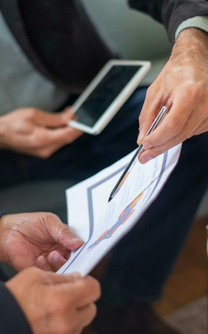 Close-up of two business professionals discussing documents in a meeting.